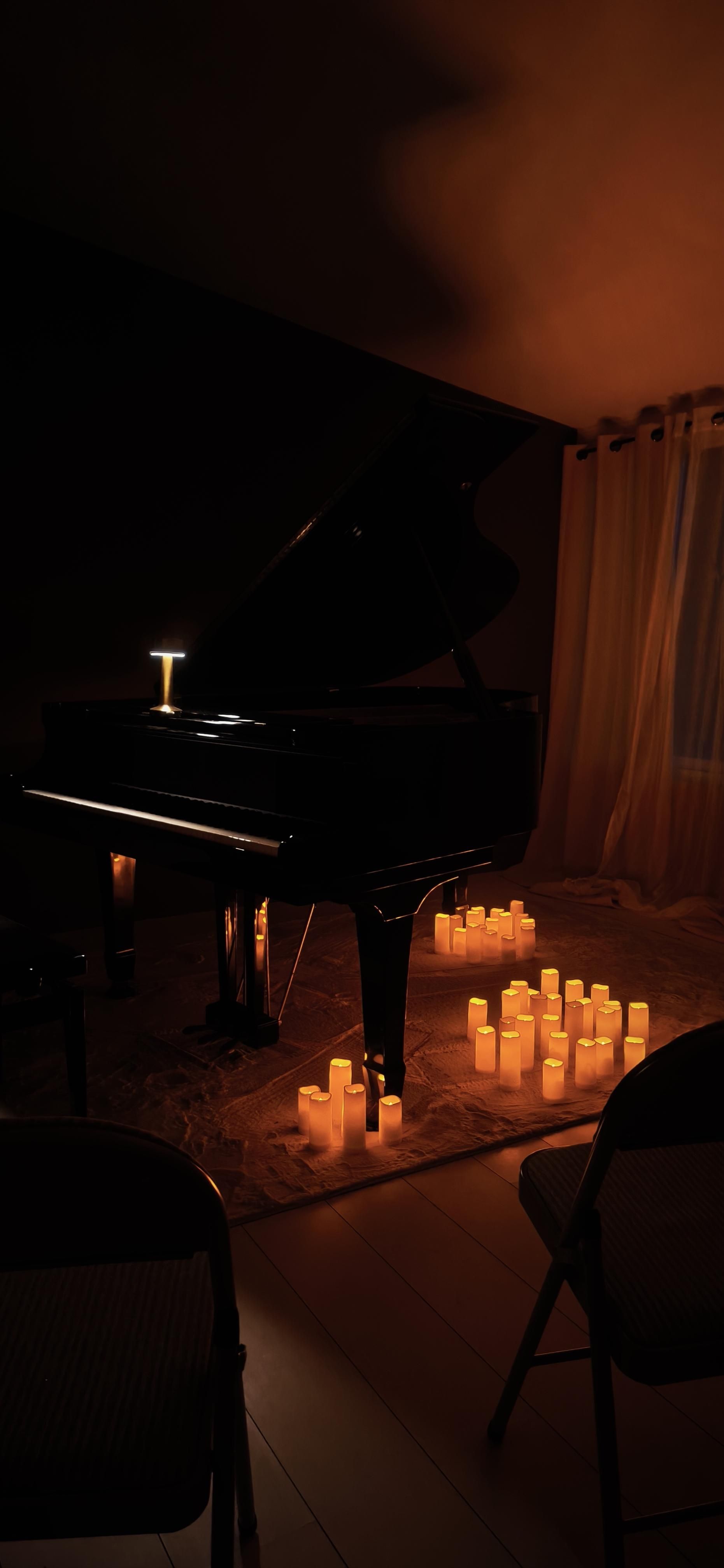 Piano à queue ouvert, bougies au sol
