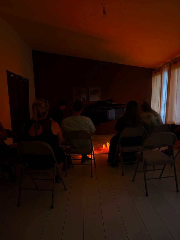 Public assis autour du piano pendant le concert